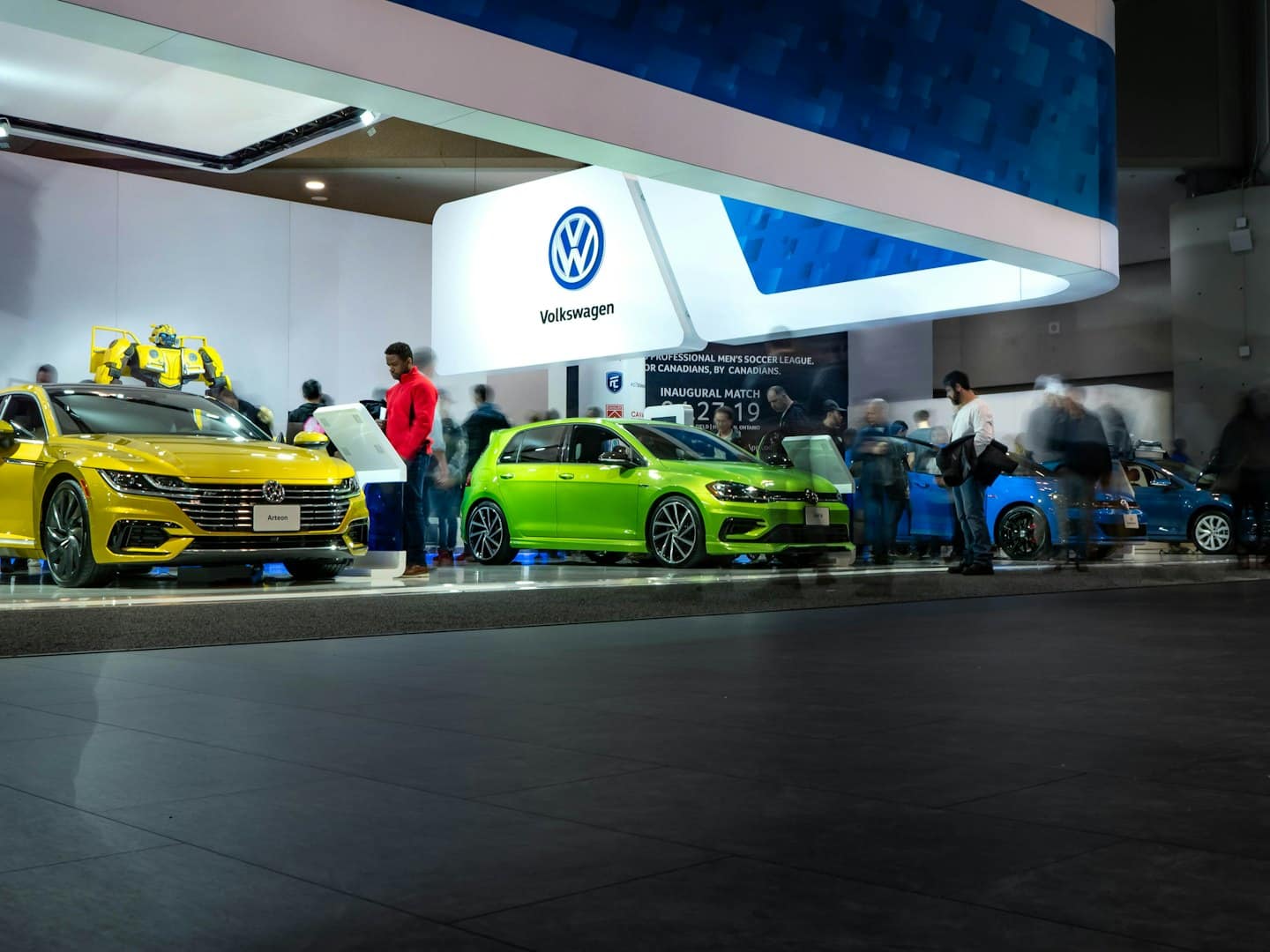 New Volkswagen cars displayed at an indoor exhibition event.