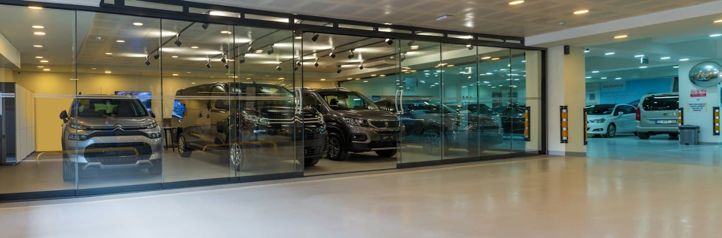 New cars displayed inside a modern car dealership showroom.